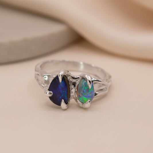 silver ring with two opals, in a claw setting