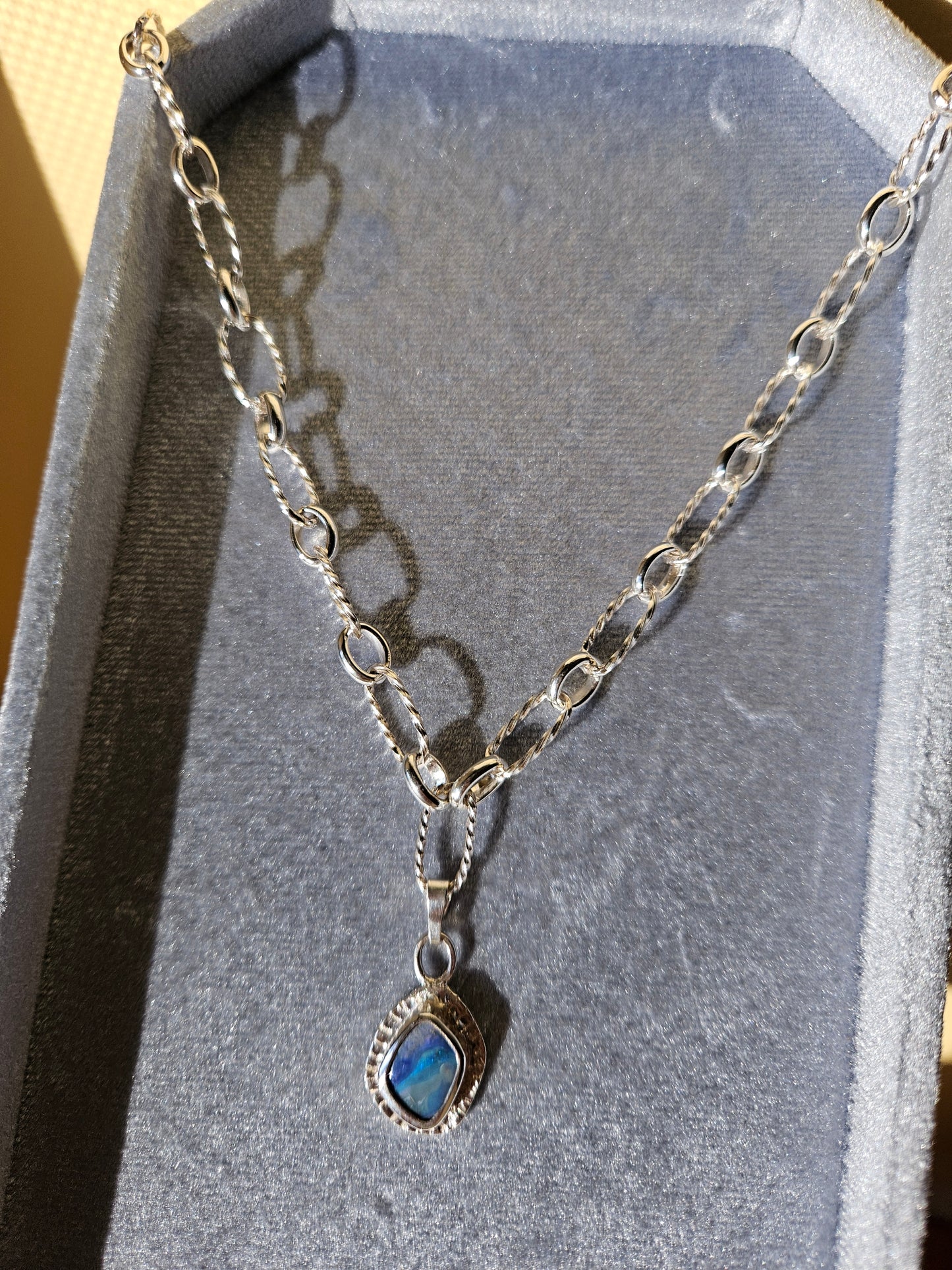 Silver chain necklace with a blue opal gemstone pendant